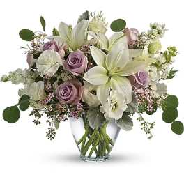 Lavender roses and white lilies in a clear glass vase