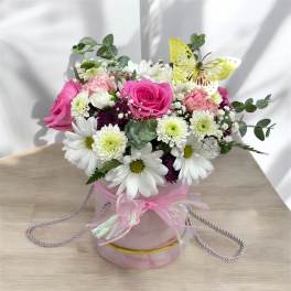 Round pink hatbox arrangement with pink roses, white daisies, and a yellow decorative butterfly.