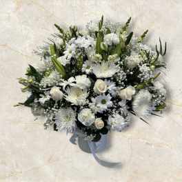 White floral arrangement in a ribbed vase with a ribbon