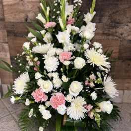 Tall white and pink floral arrangement with roses, carnations, and spider mums