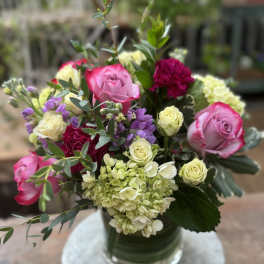 Pink and cream roses with hydrangeas in a glass vase