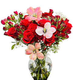 Red roses and pink lilies in a clear glass vase