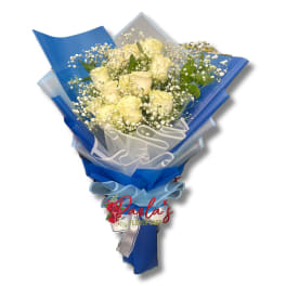 Bouquet of pale yellow roses wrapped in blue paper