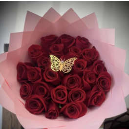 Bouquet of red roses wrapped in pink paper with a butterfly decoration