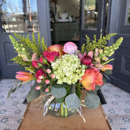 Colorful bouquet in a glass vase with roses, hydrangea, and tulips