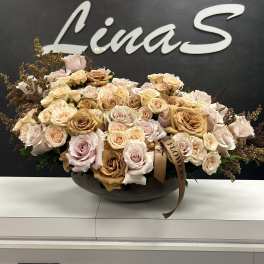 Large bouquet of pale roses in a low dark bowl
