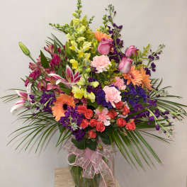 Mixed bouquet in a glass vase with pink, purple, orange, and yellow flowers