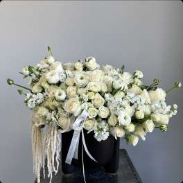 Cream rose bouquet in a black container with white ribbon