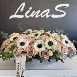 Blush rose arrangement with white anemones in a low oval container