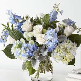 Blue and white flower arrangement in a clear glass vase