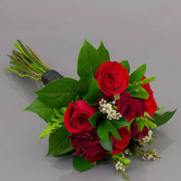 Bouquet of red roses with green leaves and small white filler flowers