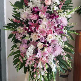Large pink and white funeral spray on a standing easel