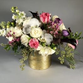 Mixed bouquet in a gold vase with pink, white, and purple flowers