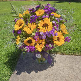 Bouquet of sunflowers and purple flowers in a glass vase
