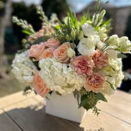 Peach roses and white hydrangeas in a white box arrangement