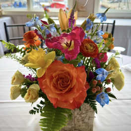 Colorful mixed flower arrangement in a square vase