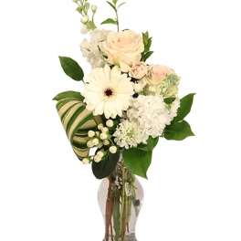 White floral bouquet in a clear glass vase with a striped ribbon