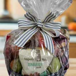 Gift basket wrapped in clear cellophane with a striped bow