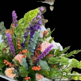 Bouquet of pink roses and purple flowers with orange berries