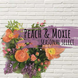 Peach and purple mixed flower arrangement in a glass vase
