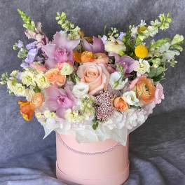 Pastel bouquet in a pink hat box with roses and orchids