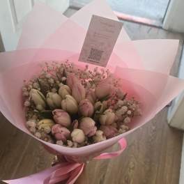 Pink and white tulip bouquet wrapped in pink paper with a ribbon