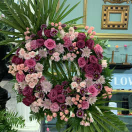 Large pink and purple floral wreath with palm fronds