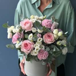 Pink and white flowers arranged in a round hatbox