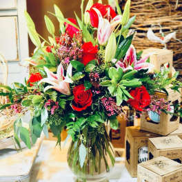 Bouquet of red roses and pink lilies in a glass vase