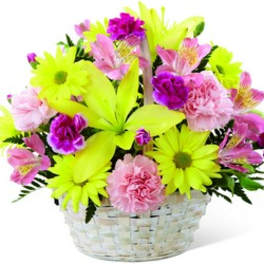 Bright mixed bouquet in a white basket with neon yellow daisies and pink flowers