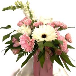 Pink and white flowers arranged in a pink vase