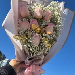 Bouquet of pale pink roses with white baby's breath and butterfly accents
