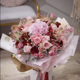 Pink and red rose bouquet wrapped in pale paper