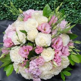 Bouquet of white and pink roses with green foliage