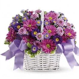 Basket of purple and pink daisies with a lavender ribbon
