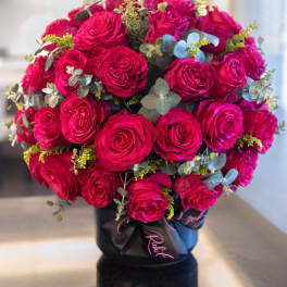Bouquet of hot pink roses in a black hatbox