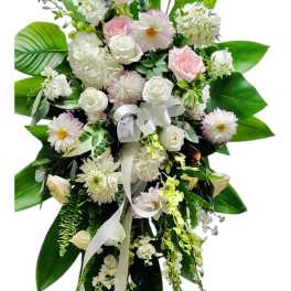 Standing floral spray with white and pale pink flowers on a white ribbon