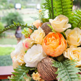 Bouquet of cream and orange roses with fern leaves