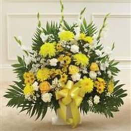 Yellow and white floral standing spray with a ribbon on a white easel
