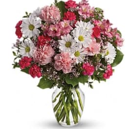 Pink and white mixed flowers in a clear glass vase
