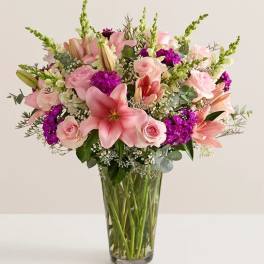 Pink lilies and roses in a clear glass vase