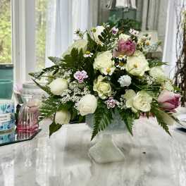 White and pink floral arrangement in a pedestal vase