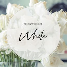 White roses in a clear glass vase with a "Designer’s Choice White" label