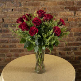 Red roses arranged in a clear glass vase