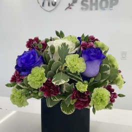 Mixed bouquet of roses and carnations in a black square vase