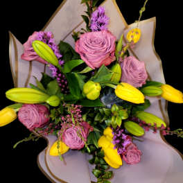 Bouquet of pink roses and yellow tulips with purple accents