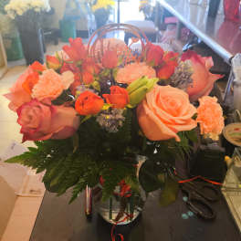 Peach and coral rose bouquet in a clear vase