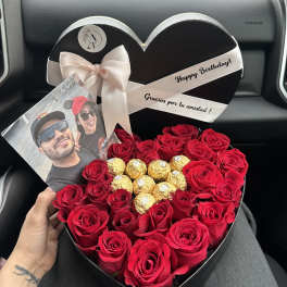 Heart-shaped box of red roses with gold chocolates and a photo card