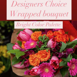 Bright mixed bouquet with pink, orange, and purple flowers wrapped in brown paper