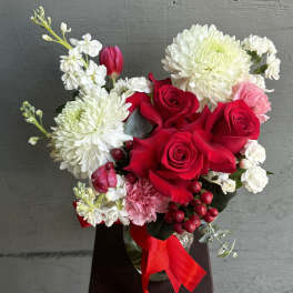 Bouquet of red roses, white chrysanthemums, and pink carnations with a red ribbon
